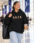 Lifestyle photo of the 5, 6, 7, 8 Puff Hoodie in Black