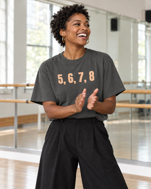 Lifestyle photo of the 5, 6, 7, 8 Puff Tee in Pepper